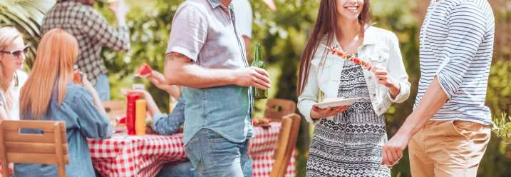 Gruppe von Personen bei einer Grillparty im Garten.